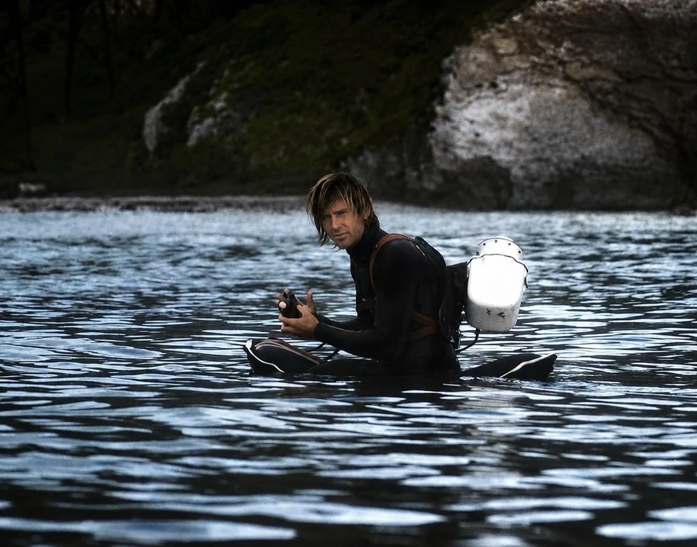 George Greenough sitting in the water with his filming equipment.